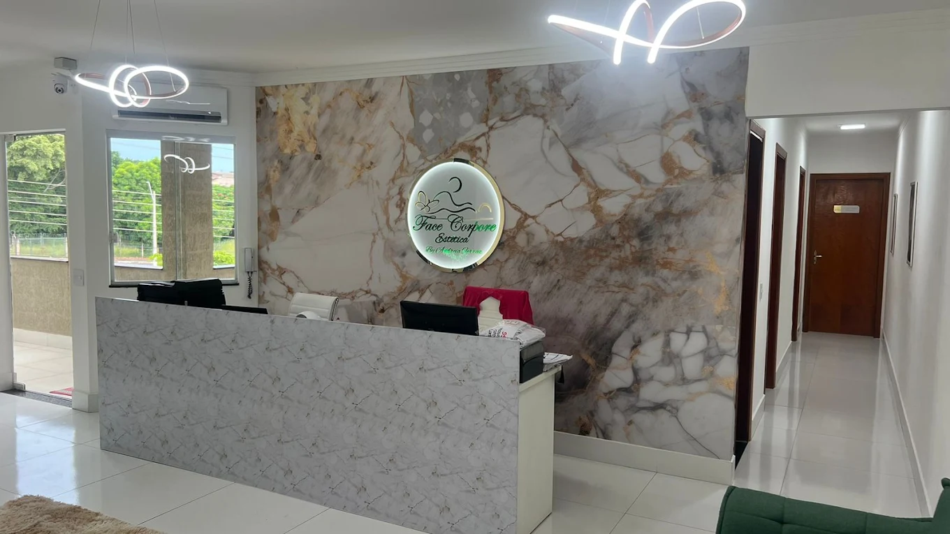 Recepção da Face Corpore, com parede de mármore e logo iluminado